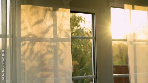 Sunset through the transparent curtains at the window, autumn time