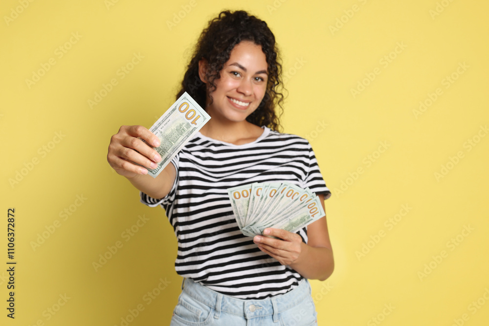 Happy woman with dollar banknotes on yellow background Happy woman with dollar banknotes on yellow background