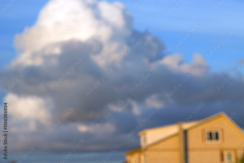 unfocused yellow brick house and dark sormy cloud in blue evening sky unfocused yellow brick house and dark sormy cloud in blue evening sky