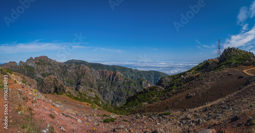 PICO DO ARIEIRO, MADEIRA - OCTOBER 2021: Group of tourists hiking in the mountains of Madeira from Pico do Areeiro Arieiro to Pico Ruivo on a sunny autumn day photo