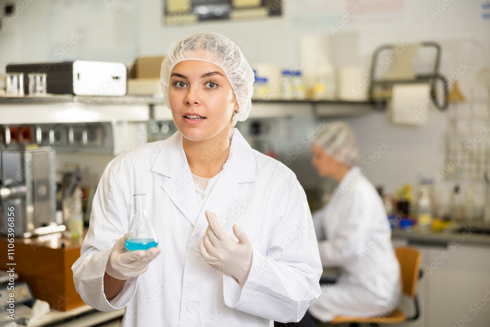 Young woman scientist in a medical coat conducts experiments with liquids in the laboratory Young woman scientist in a medical coat conducts experiments with liquids in the laboratory