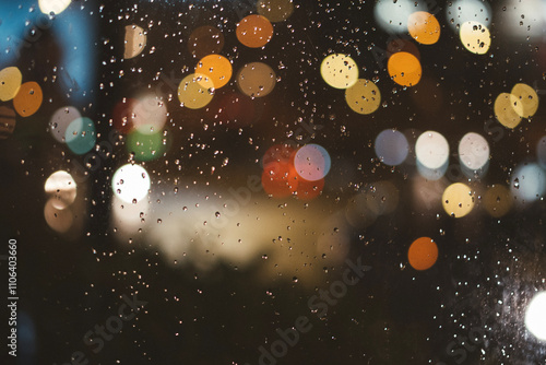 blur colorful lights with raindrops on glass photo