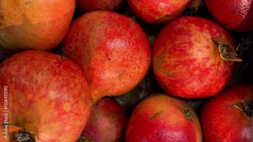 Pomegranates arranged in crates on greengrocer's counter, tracking shot of pomegranates in top view