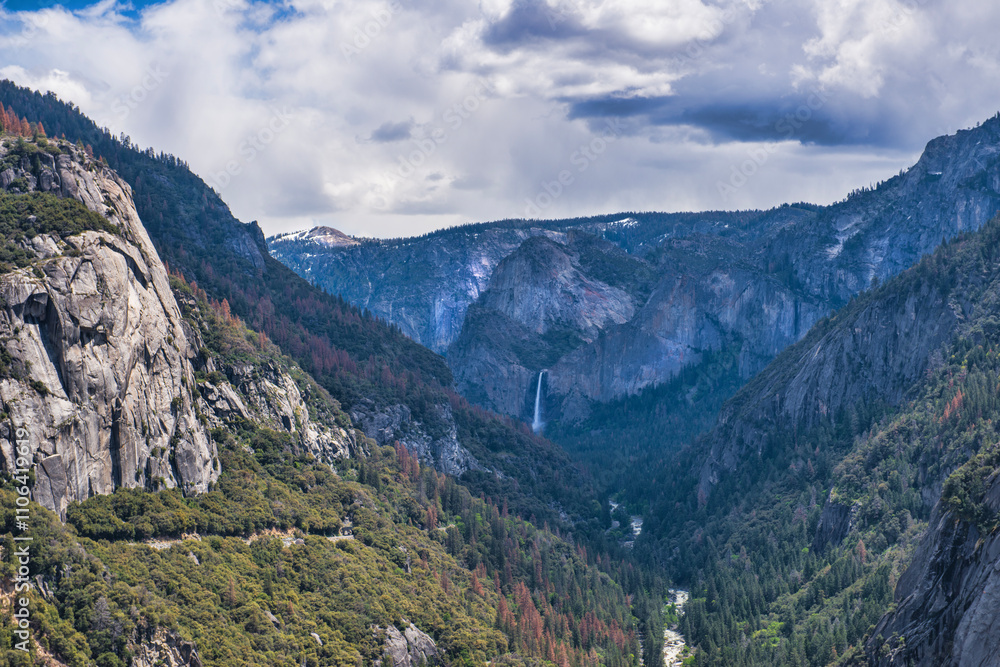 Waterfall and mountains with river running through forest valley at Yosemite National Park. Waterfall and mountains with river running through forest valley at Yosemite National Park.