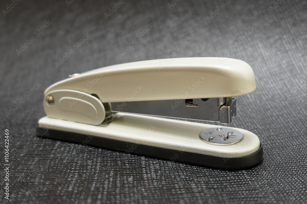 Close-Up of a Black and White Stapler: A Blend of Functionality and Minimalist Design Highlighted Against a Textured Background Close-Up of a Black and White Stapler: A Blend of Functionality and Minimalist Design Highlighted Against a Textured Background