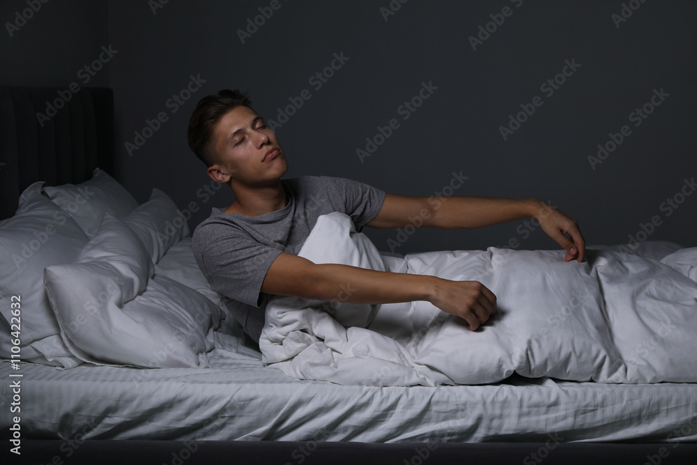 Young man suffering from sleepwalking on bed at home Young man suffering from sleepwalking on bed at home