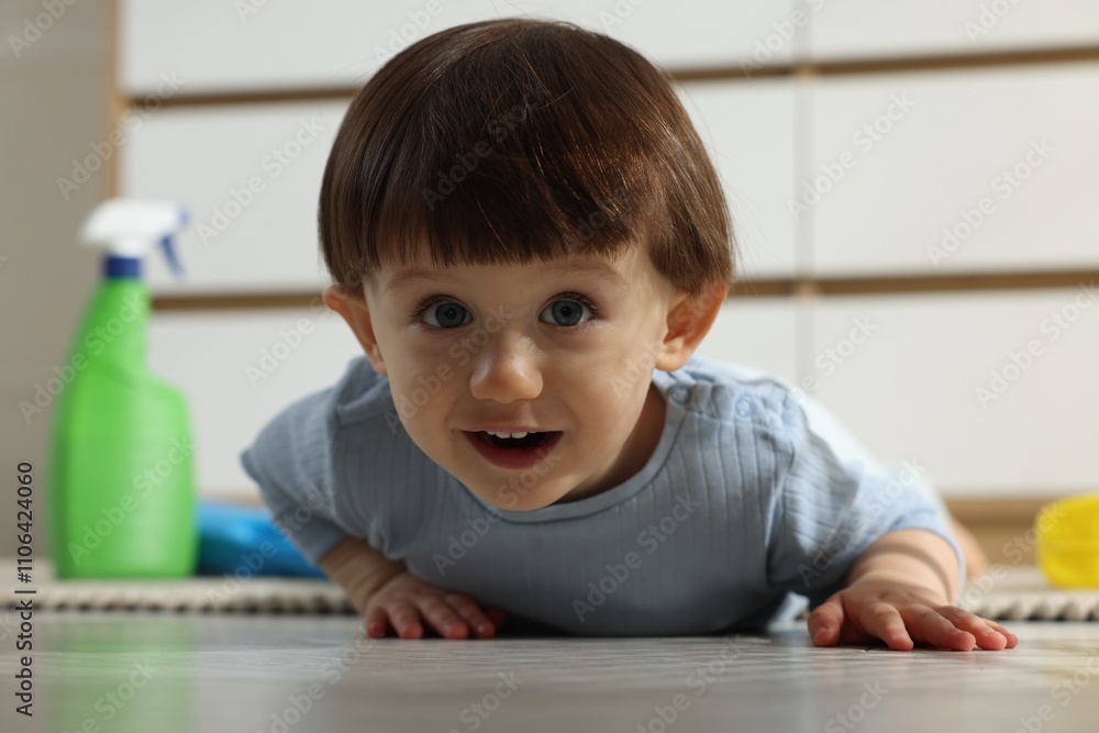 Little boy among bottles of detergents on floor at home. Child in danger Little boy among bottles of detergents on floor at home. Child in danger