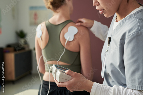 Tableau sur toile Physiotherapist conducting physical therapy session with patient using electroni