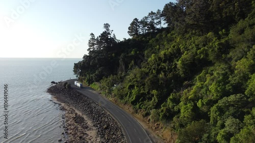Truck driving along scenic coastal road in new zealand