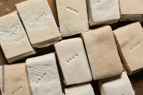 Obraz na plátně Overhead view of hardtack bread on a wood chopping board, top view of nigerian h