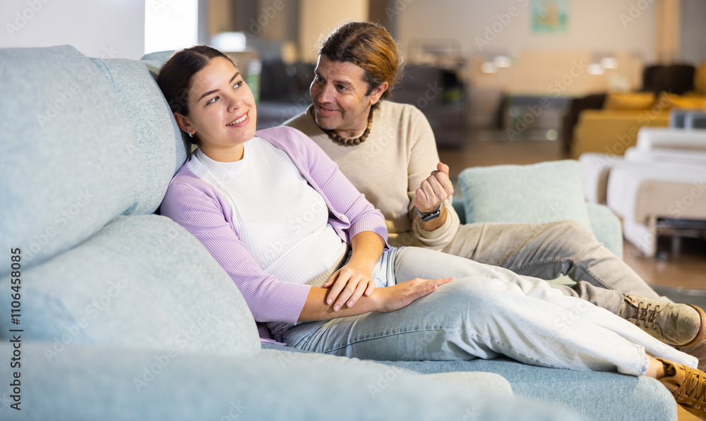 Potential buyers trying and checking a new sofa Potential buyers trying and checking a new sofa