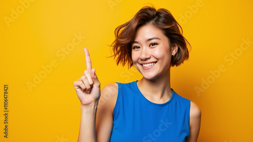 Confident Young Woman Pointing Upward: Vibrant Portrait for Motivational Campaigns or Personal Branding