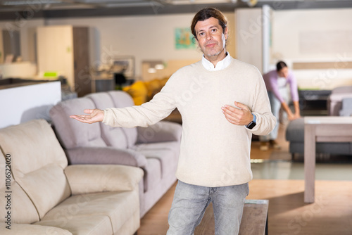 Furniture salesman offering choice of sofas in furniture store photo