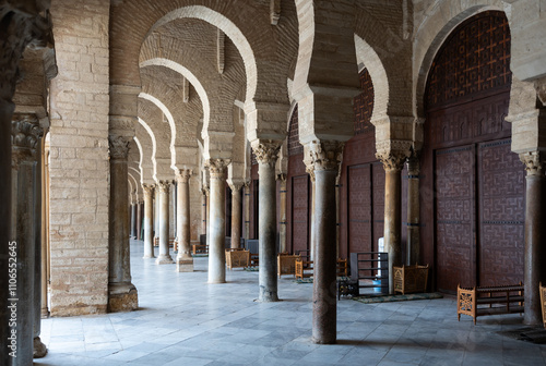 Corridor gallery around inner courtyard of Great Mosque of Kairouan in Tunisia with traditional Islamic arches and columns decorated with Corinthian capitals photo