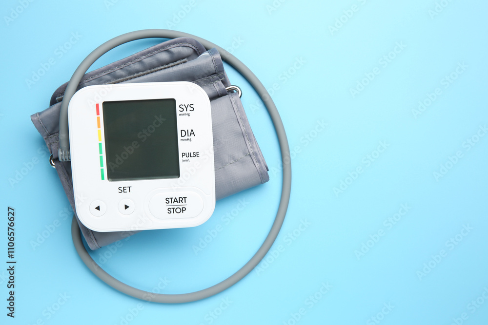 Blood pressure measuring device on light blue background, top view. Space for text Blood pressure measuring device on light blue background, top view. Space for text