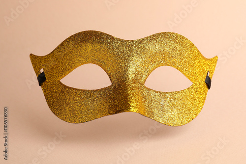 Beautiful golden carnival mask on beige background photo