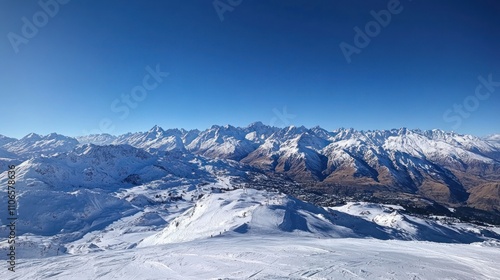 A stunning panoramic view of snow-covered mountains under a clear blue sky.