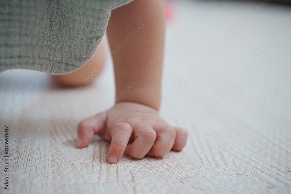 Close up baby hands on a wooden laminate floor. Bare hands a baby in the living room floor. Crawling development. Close up baby hands on a wooden laminate floor. Bare hands a baby in the living room floor. Crawling development.