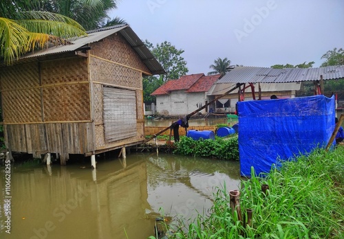 Local houses in the village with ornaments made of bamboo, traditional bathrooms. Next to the house there are coconut trees,and around it there are traditional fish farms.Buildings and natural scenery