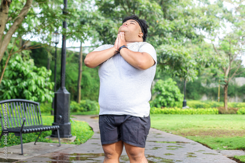 Overweight Guy In Sportswear Stretching His Head Before Workout in The Park Overweight Guy In Sportswear Stretching His Head Before Workout in The Park
