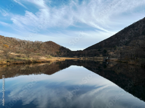 日本の群馬県にある赤城山の覚満淵／中央に鳥居峠が反射するカルデラ湖と秋空のコピースペース
