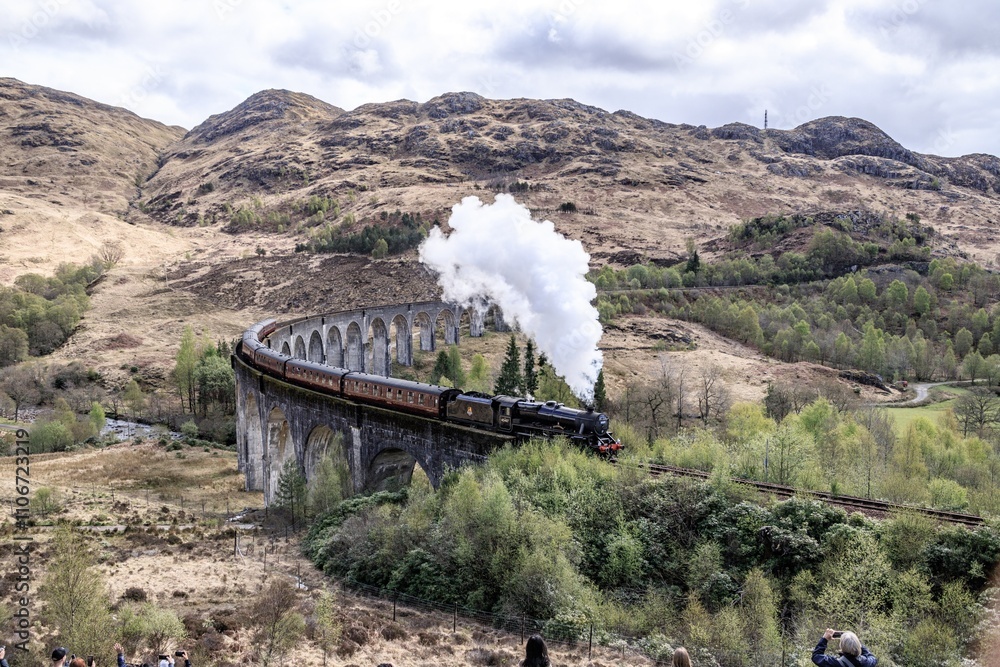 Fototapeta premium Majestic Steam Train Chugging Across the Glenfinnan Viaduct, Glencore, Scotland