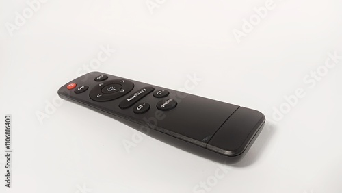 The remote control is black with a sleek design on a white background