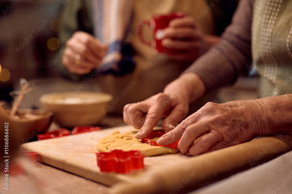 Close up of senior woman using cookie cutter while baking for Christmas. Close up of senior woman using cookie cutter while baking for Christmas.