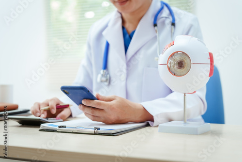 A male doctor wearing glasses sits at a desk in a hospital, explaining eye diseases like glaucoma, cataracts, pterygium, and diabetic retinopathy. Early detection helps prevent vision loss photo