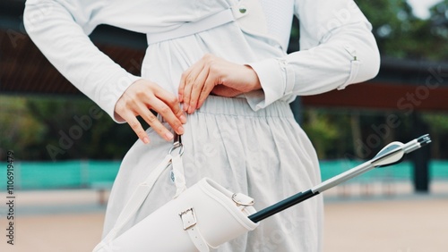 Arrow, gear and person with outdoor archery training, target practice and professional Japanese athlete. Setup, belt and archer with sports challenge, getting ready and equipment at kyudo club photo