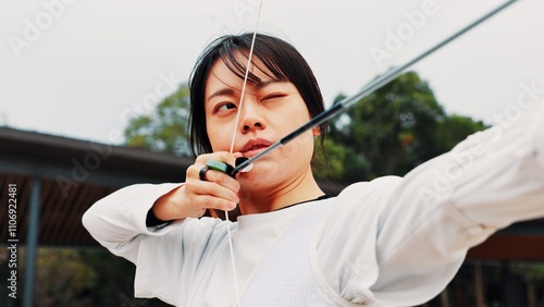 Woman, archery and arrow at field with sport for shooting practice and training as athlete in Japan. Tournament, female person and setup recurve bow or equipment for challenge, game and competition photo