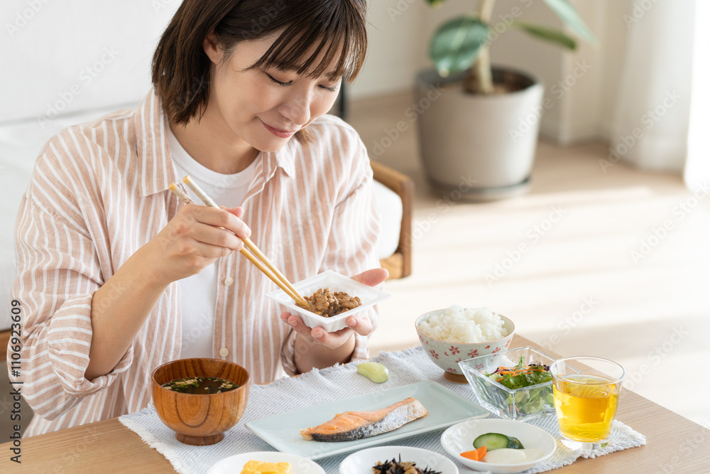 朝食で納豆を食べる若い女性