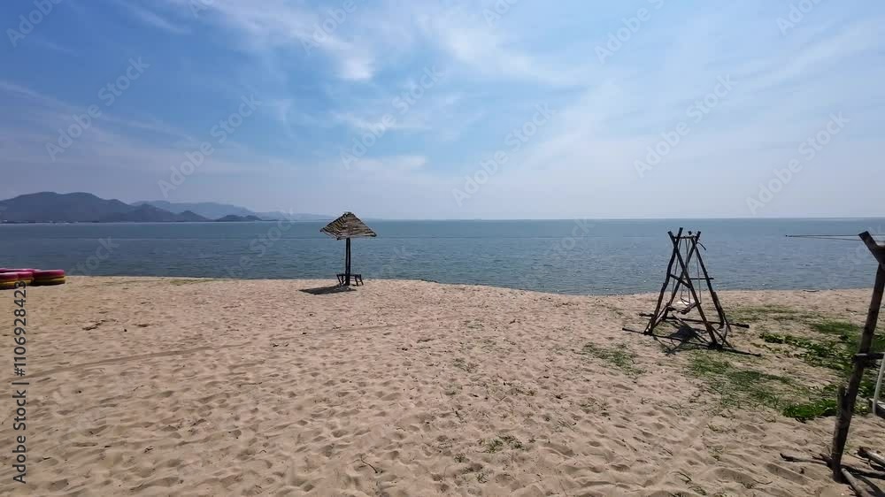 Wooden Swing and Sun Umbrella at empty Beach with no People on a Sunny Day in Phan Rang, Vietnam.
Offering a dynamic view with Mountains and Ocean in Background Wooden Swing and Sun Umbrella at empty Beach with no People on a Sunny Day in Phan Rang, Vietnam.
Offering a dynamic view with Mountains and Ocean in Background