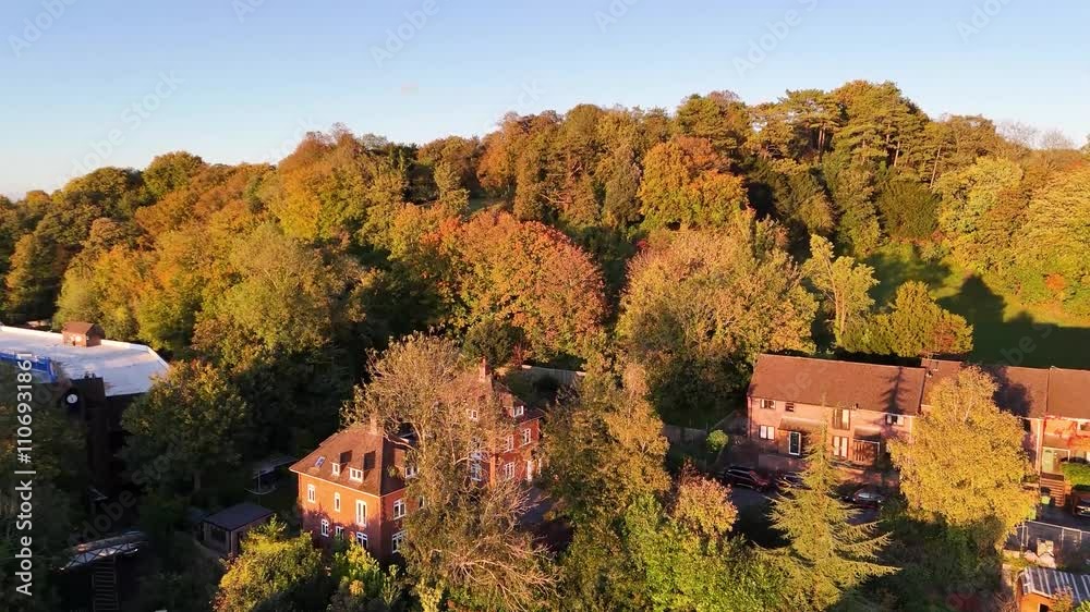 Spectacular Autumn trees surrounding houses drenched in sunshine on a hillside in Winchester in the golden hour, rising footage Spectacular Autumn trees surrounding houses drenched in sunshine on a hillside in Winchester in the golden hour, rising footage