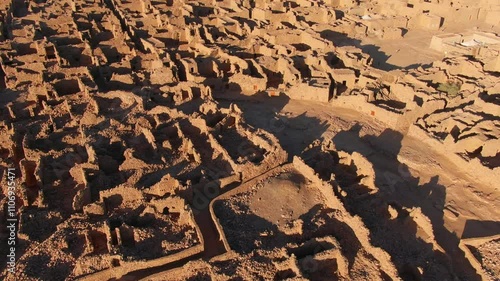 Ouadane or Wadan ancient city, ruins, Mauritania in Africa. Aerial backward tilt-up reveal, sky for copy space photo