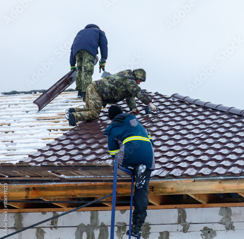 Wallpaper Mural Three men are working on a roof, one of them is wearing a yellow vest Torontodigital.ca