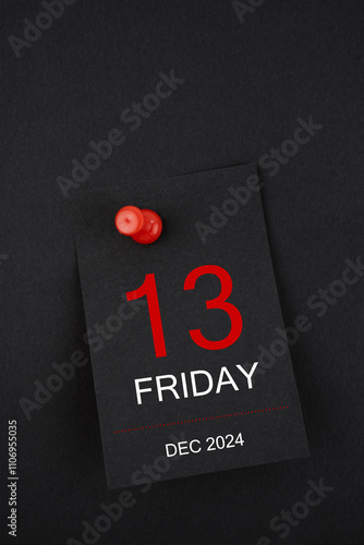 Calendar Friday the 13th December 2024 and push pin on black background.