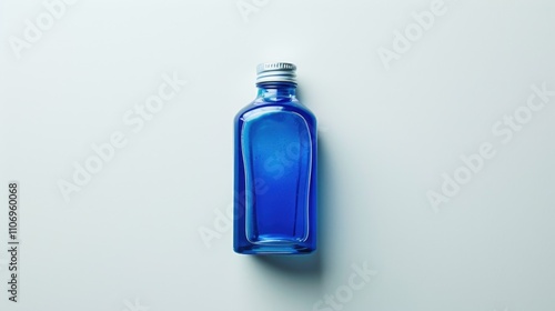 Blue bottle of perfume is sitting on a white background. The bottle is made of glass and has a silver cap. The bottle is the main focus of the image, and it is a small, delicate object