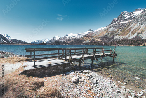 Wooden jetty in mountain lake photo