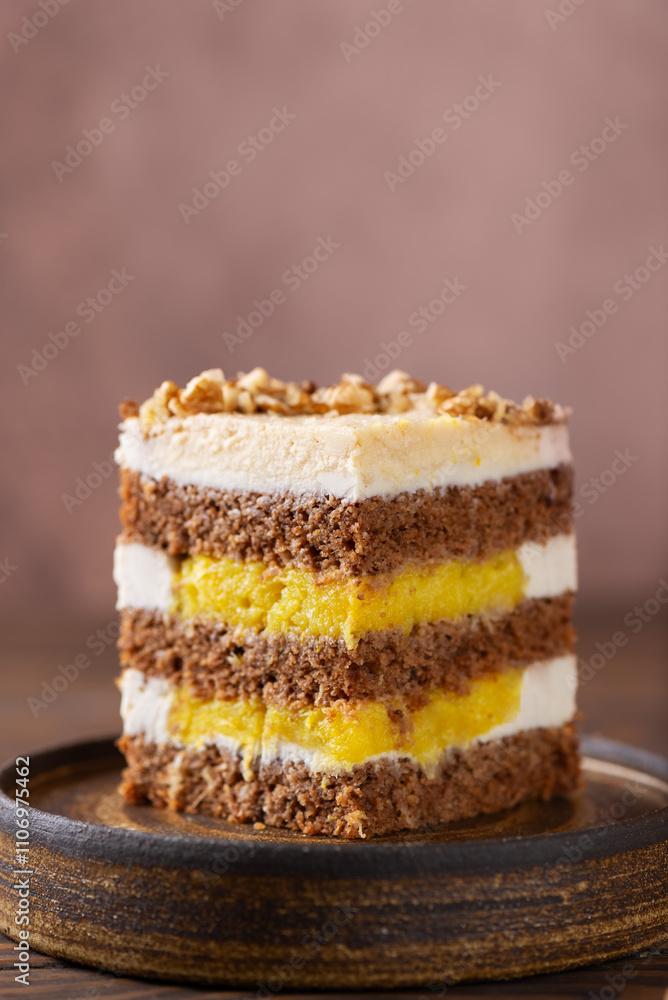 Piece of pumpkin or carrot layered cake with coconut cream, walnut and orange confit in a plate. Sugar, gluten and lactose free. Vegan, healthy dessert. Vertical orientation. Piece of pumpkin or carrot layered cake with coconut cream, walnut and orange confit in a plate. Sugar, gluten and lactose free. Vegan, healthy dessert. Vertical orientation.