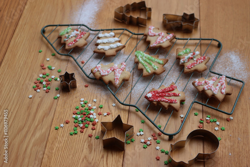 Christmas tree shaped gingerbread cookies  on a cooling rack in shape of a tree on wooden table  photo