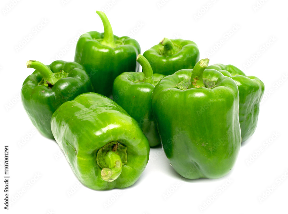 A bunch of green peppers are piled on top of each other A bunch of green peppers are piled on top of each other