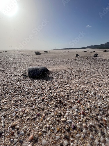 Fotos aras del suelo, la arena se levanta por la brisa, las piedras salpicadas por los granos, atardecer en playa desierta en la costa photo