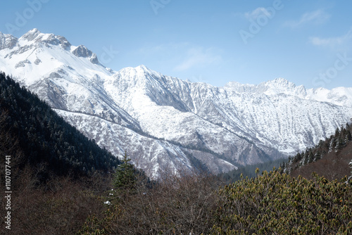 View of beautiful the mountain in sunny blue sky at Huanglong national scenic parkland in Sichun, China that covered with snow in winter season. Nature and outdoor scape photo. photo