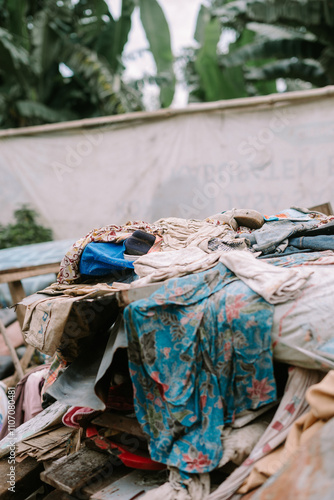 A pile of worn-out and unusable clothes discarded in a trash bin photo