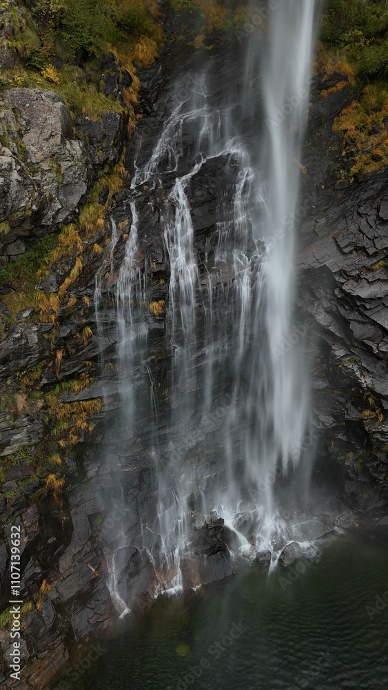 Obraz premium Stunning Waterfall Over Rocky Cliffs