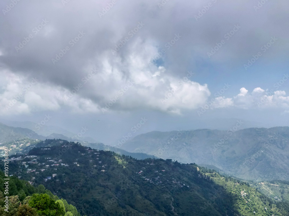 A scenic view of lush green mountains under a cloudy sky.Rolling hills dotted with houses create a serene and peaceful atmosphere, perfect for themes of nature, tranquility and outdoor beauty in india A scenic view of lush green mountains under a cloudy sky.Rolling hills dotted with houses create a serene and peaceful atmosphere, perfect for themes of nature, tranquility and outdoor beauty in india