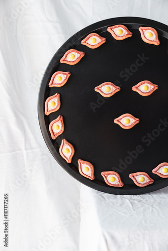 A front view of khachapuri magnets on a black tray, arranged symmetrically for an elegant and contemporary look, perfect for home or kitchen decor