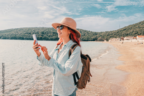Obraz na płótnie Tourist using smartphone on the beach of Jaz, Montenegro w salonie