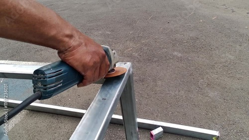 Focus hand worker or male welder using grinding machine after welding aluminum. Grinding machine is used to clean and smooth the weld joint.